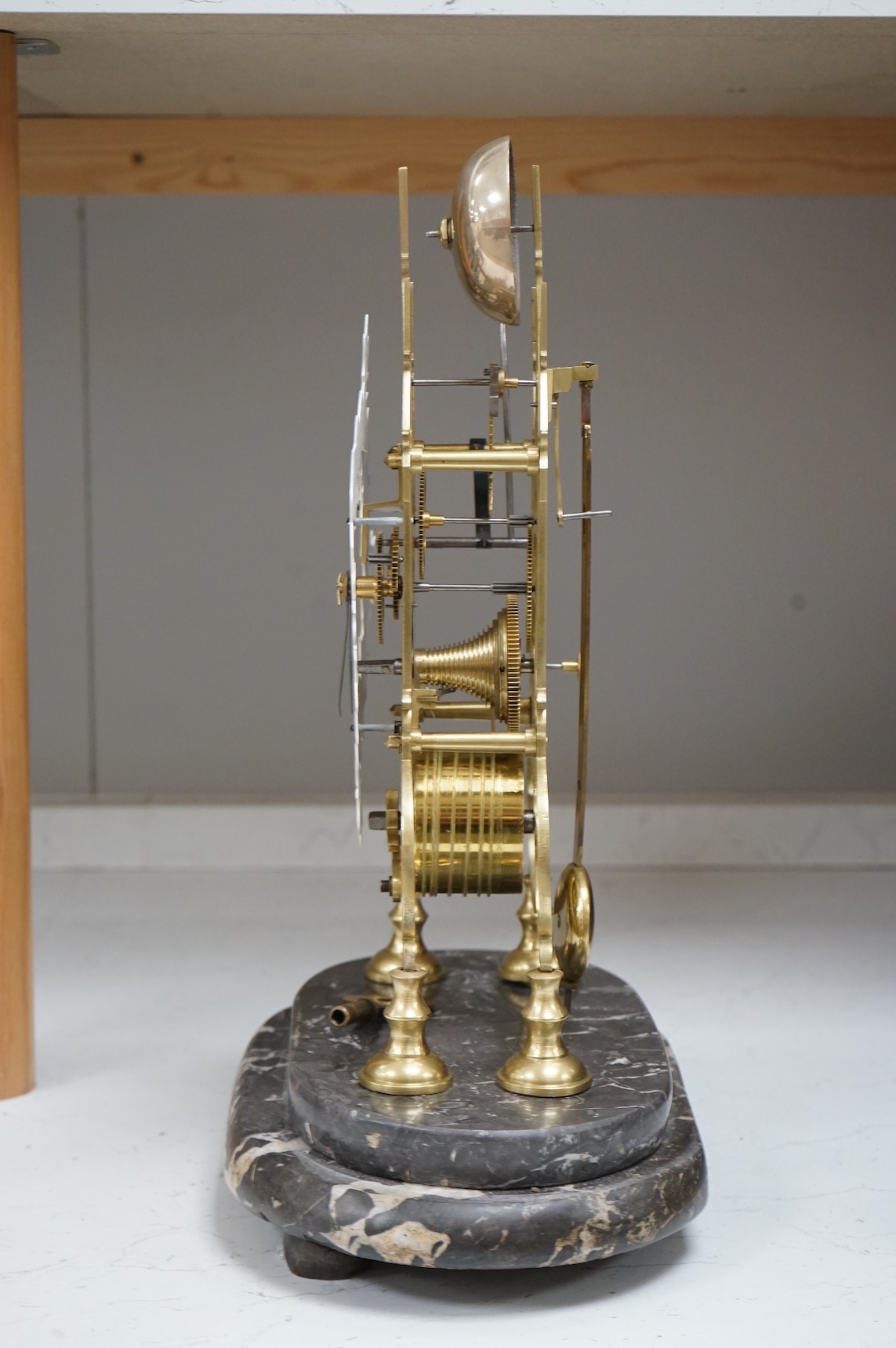 A large skeleton clock under dome, on grey marble base. 44cm high